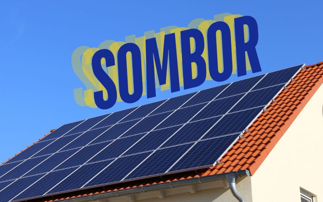 Solarni paneli na krovu kuće u Somboru pod vedrim nebom, sa istaknutim natpisom Sombor u pozadini.